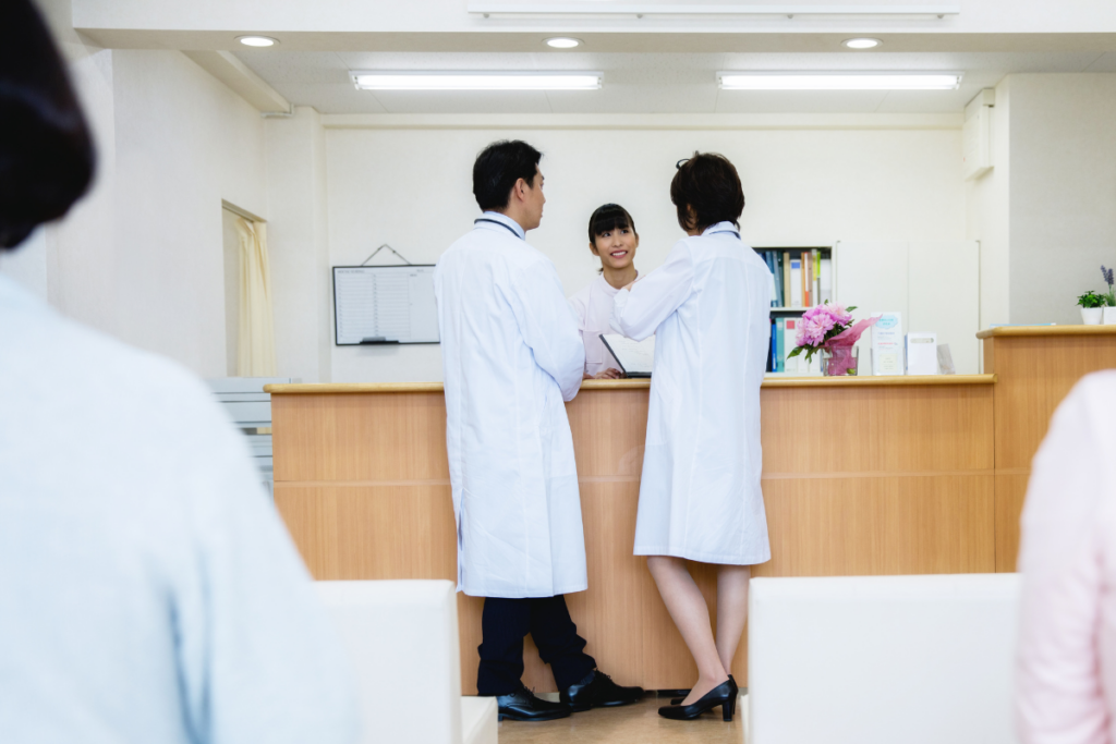 profissionais trocando informações na recepção de clínica. Imagem ilustrativa para texto Produtividade da recepção hospitalar.