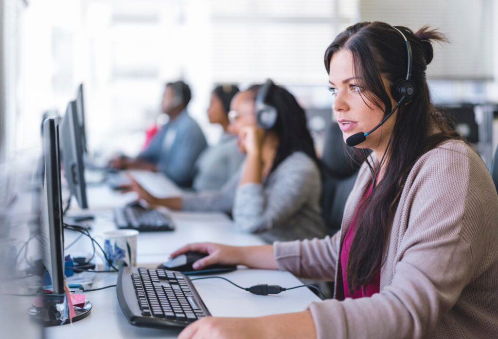 profissional utilizando computador e atendendo paciente via service desk.