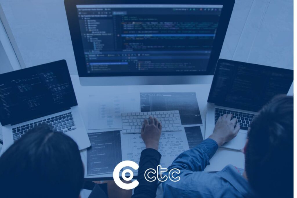 dois técnicos de TI utilizando computador mostrando a interoperabilidade na saúde capa