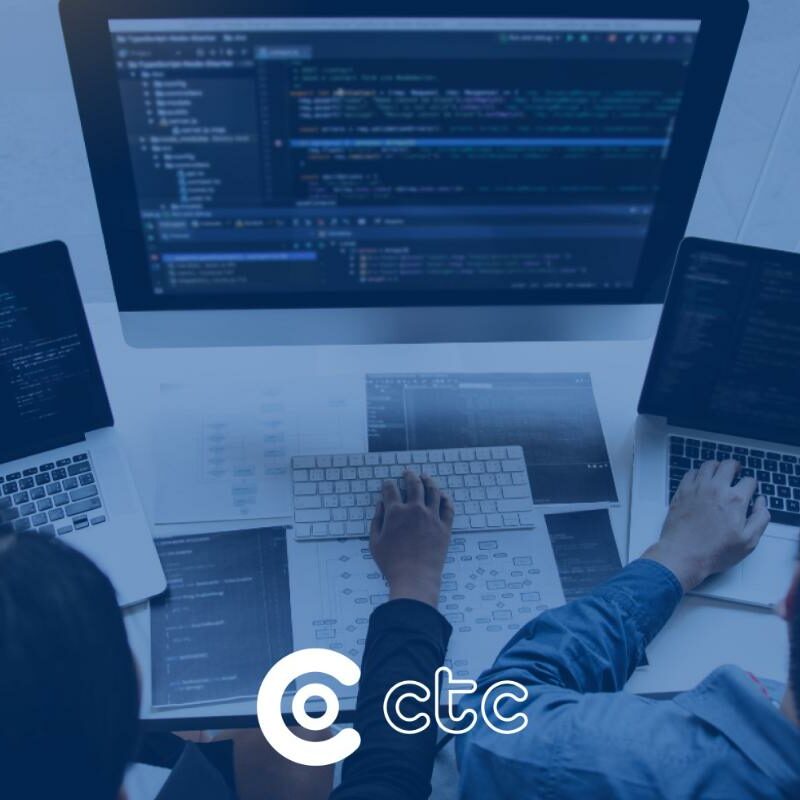 dois técnicos de TI utilizando computador mostrando a interoperabilidade na saúde capa