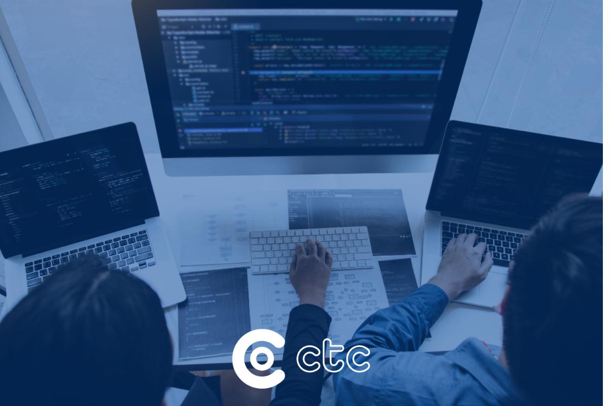 dois técnicos de TI utilizando computador mostrando a interoperabilidade na saúde capa