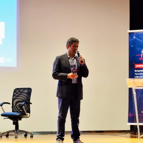 Pessoa de pé falando com microfone