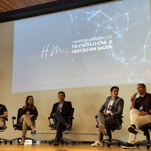 Palestrantes sentados no Simpósio Mineiro de Tecnologia e Gestão em Saúde